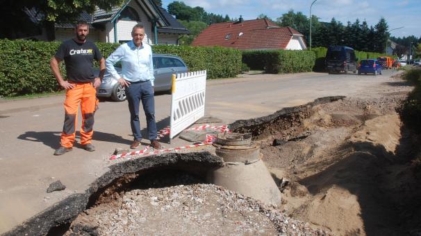 <p>Im Hellenthaler Ortsteil Wiesen-Reifferscheid hat der sturzflutartig zu einem reißenden Strom angeschwollene Reifferscheider Bach ganze Straßenteile weggerissen. Bürgermeister Rudolf Westerburg (rechts) ist froh über die unbürokratische Hilfe aus Büllingen bei der Behebung der Schäden.</p>