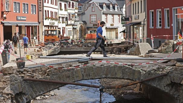 <p>Ein Mann geht über die Brücke in der Altstadt von Bad Münstereifel. Das Hochwasser hat erhebliche Schäden in der deutschen Eifel angerichtet.</p>