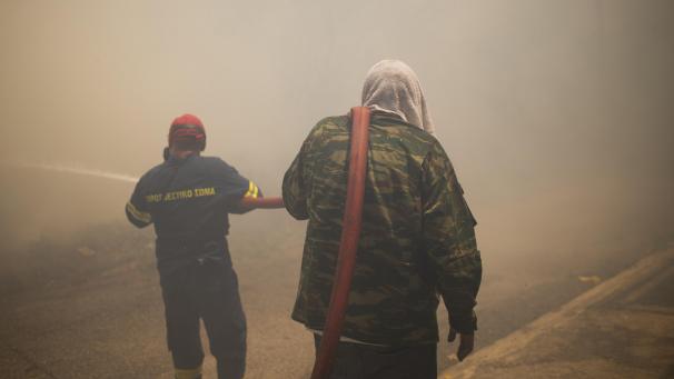 <p>Feuerwehrleute und Freiwillige versuchen ein Feuer in einem Wohngebiet nördlich von Athen zu löschen.</p>