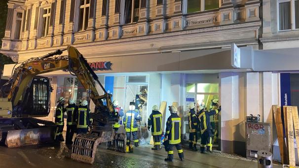 <p>Feuerwehrleute stehen vor dem Haus, in dem mehere Geschossdecken eingesackt sind.</p>