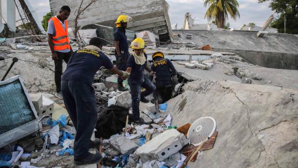 <p>Einsatzkräfte der Feuerwehr suchen zwischen den Trümmern eines durch ein Erdbeben eingestürztes Haus nach Überlebenden.</p>
