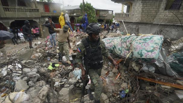 <p>Ein Soldat (rechts) steigt am Morgen nach dem Tropensturm Grace über Schutt und Geröll, drei Tage nach dem Erdbeben der Stärke 7,2.</p>