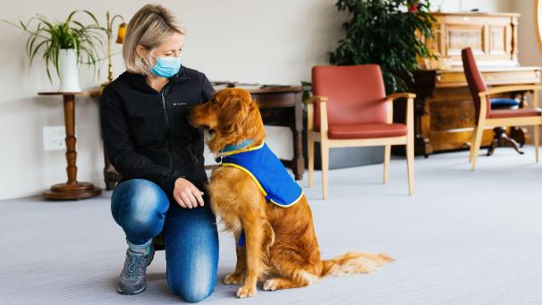 <p>Hundeführerin Christelle Schreiber kniet neben Pokaa, dem laut ihr ersten in Frankreich eingesetzten Covid-Suchhund.</p>