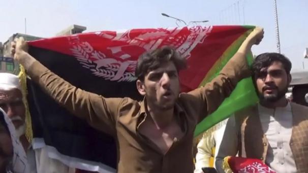 <p>Ein Mann hält die Flagge Afghanistans während einer Demonstration in Jalalabad.</p>