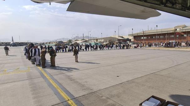 <p>Afghanen stehen in einer Warteschlange, um in ein Flugzeug C130J der italienischen Luftwaffe vom Flughafen Kabul evakuiert zu werden.</p>