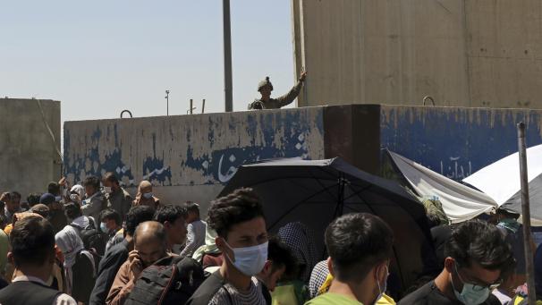 <p>Ein US-Soldat steht Wache, während sich Hunderte von Menschen in der Nähe eines Kontrollpunktes auf dem Gelände des internationalen Flughafens Hamid Karzai in Kabul im Rahmen der Evakuierungen versammeln.</p>