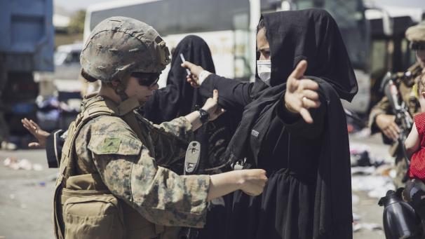 <p>Ein US-Marine überprüft eine afghanische Frau, während sie das Evakuierungskontrollzentrum am Flughafen von Kabul durchläuft.</p>