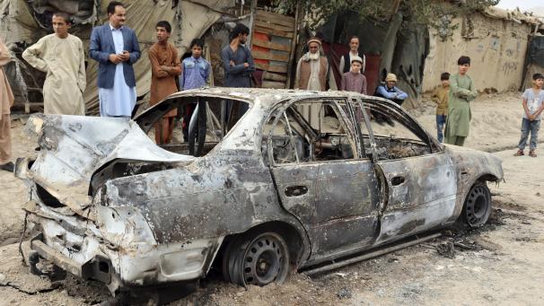 <p>Anwohner betrachten ein beschädigtes Fahrzeug: In Kabul hat es einen Raketenangriff gegeben.</p>