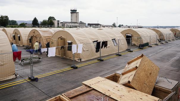 <p>Aus Afghanistan evakuierte Menschen stehen auf der Ramstein Air Base zwischen Zelten. US-Außenminister Antony Blinken will in der kommenden Woche den amerikanischen Militärstützpunkt Ramstein in Rheinland-Pfalz besuchen.</p>
