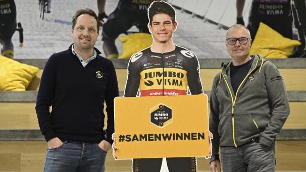 <p>Jumbo-Visma-Sportdirektor Merijn Zeeman und der Trainer von Wout van Aert, Marc Lamberts, posieren mit einem lebensgroßen Aufsteller des Ausnahmefahrers.</p>