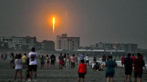 <p>Menschen beobachten am Cocoa Beach, wie eine Rakete von SpaceX vom Typ Falcon 9 vom Startkomplex 40 in Cape Canaveral abhebt.</p>
