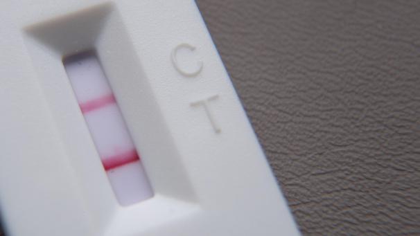 <p>Ein positiver Corona-Schnelltest liegt auf einem Tisch.</p>