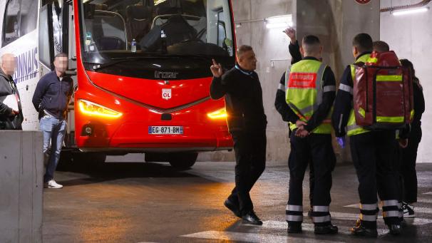 <p>Feuerwehrleute stehen neben dem Mannschaftsbus von Olympique Lyon.</p>