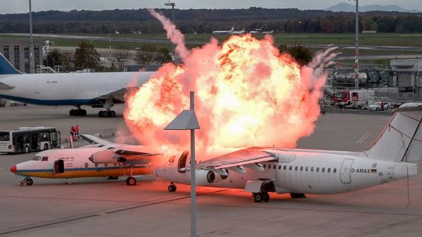 <p>Ein Feuerball ist über zwei Flugzeugen zu sehen, die am Flughafen Köln/Bonn als Notfallübung zusammengestoßen sind. An Flughäfen wird regelmäßig geübt, damit im Ernstfall die Abläufe stimmen.</p>