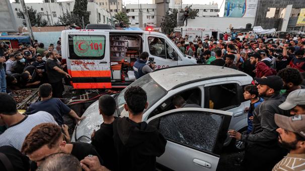 <p>Menschen versammeln sich um einen Krankenwagen, nachdem dieser vor dem Eingang des Schifa-Krankenhaus angegriffen wurde.</p>