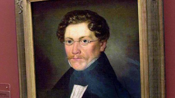 <p>Carl Spitzweg (1808-1885) blickte gemütvoll und humoristisch auf das spießbürgerliche Leben seiner Zeit: In seinen Werken porträtierte Carl Spitzweg seine Zeitgenossen mit ihren Schwächen und Eigenheiten, ohne sich über sie und ihre Biedermeier-Idylle lustig zu machen.</p>