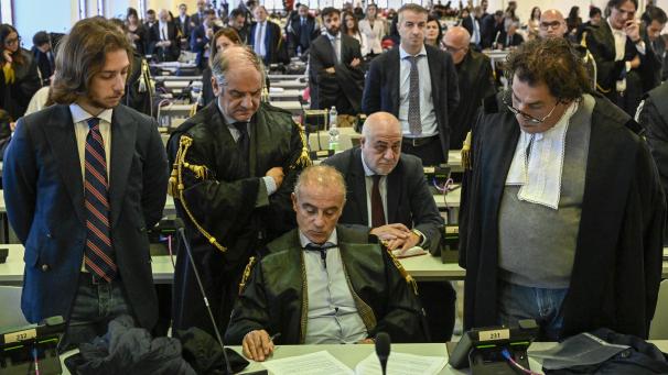 <p>Beamte hören zu, wie Richterin Cavasino die Urteile des Prozesses verliest.</p>