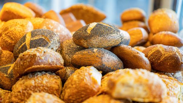 <p>Unterschiedliche Backwaren liegen in einer Bäckerei.</p>