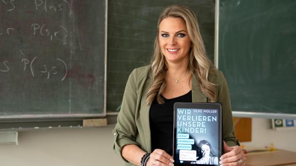 <p>Silke Müller mit ihrem Buch „Wir verlieren unsere Kinder“. Die Pädagogin will Eltern, Lehrer und die Politik wachrütteln.</p>