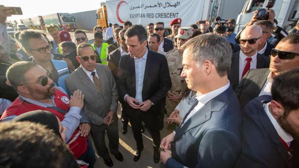 <p>Am Grenzübergang Rafah sprach De Croo (r.) mit Mitarbeitern des belgischen Roten Kreuzes. Im Hintergrund Lastwagen mit Hilfsgütern, die zunächst nicht in den Gazastreifen einfahren konnten.</p>