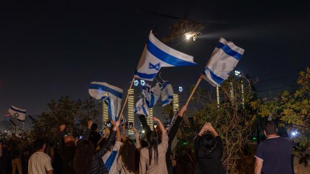 <p>Menschen schwenken israelische Flaggen, als ein Hubschrauber mit Geiseln, die im Rahmen einer Vereinbarung zwischen Israel und der islamistischen Palästinensergruppe Hamas freigelassen wurden, vom Schneider Children's Medical Center in Petah Tikva, Israel, abfliegt.</p>