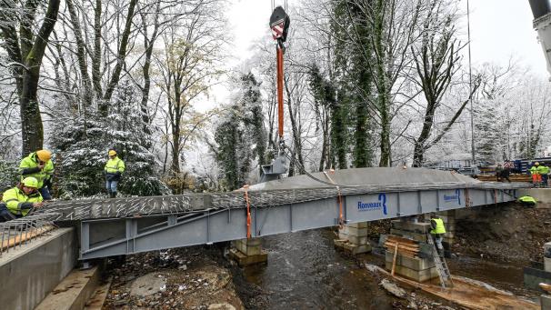 <p>Mit zwei Kränen an die richtige Stelle bugsiert: Um kurz vor 11 Uhr sitzt Seitenelement Nummer eins der neuen, rund 700.000 Euro teuren Brücke.</p>