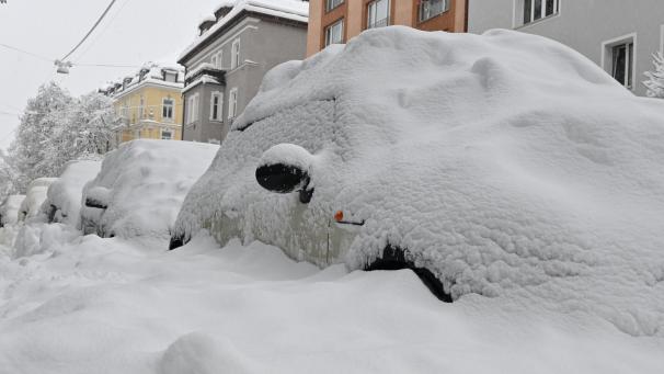 <p>Eine dicke Schneeschicht liegt auf parkenden Autos. Schnee und Eis haben im Süden Bayerns auf den Straßen und bei der Bahn für Chaos gesorgt.</p>