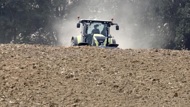 <p>Ein Traktor fährt beim Pflügen über einen staubigen Acker.</p>