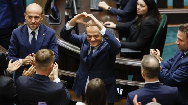 <p>Donald Tusk (Mitte), Oppositionsführer, formt nach seiner Wahl zum polnischen Premierminister im Parlament ein Herz mit seinen Händen.</p>