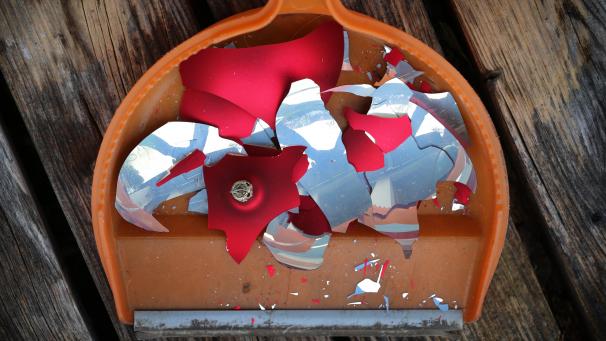 <p>Scherben einer Weihnachtskugel liegen aufgekehrt in einer Handschaufel.</p>