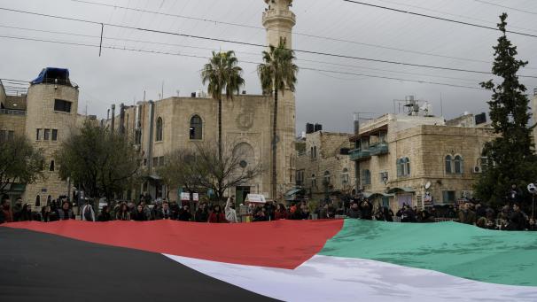 <p>Menschen halten eine riesige palästinensische Flagge auf dem Krippenplatz in der Nähe der Geburtskirche, die traditionell als Geburtsort Jesu gilt.</p>
