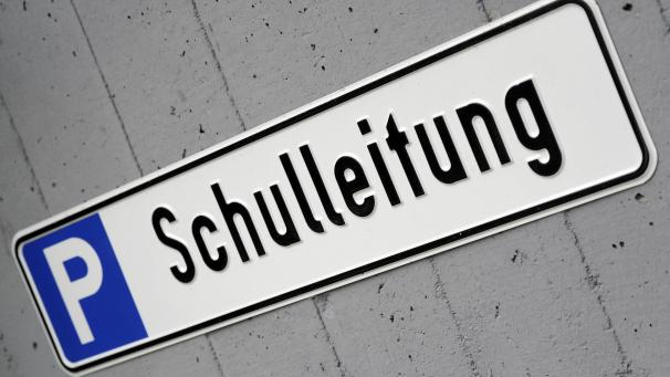 <p>Ein Schild vor einer Schule weist auf einen Parkplatz für die Schulleitung hin.</p>