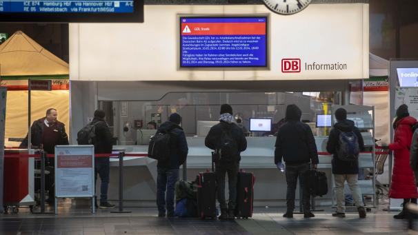 <p>Reisende stehen in Frankfurt am Main vor einem Informationsschalter.</p>