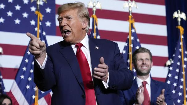 <p>Donald Trump zeigt neben seinem Sohn Eric bei einer Caucus-Party auf die Menge.</p>