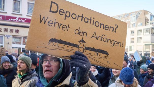 <p>„Deportationen ? Wehret den Anfängen!“ ist über einer Zeichnung des Konzentrationslagers Auschwitz auf einem Schild bei einer Demogegen Rechts in Koblenz zu sehen.</p>