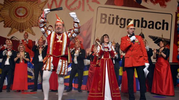 <p>Marc Bastin übernahm am Samstagabend in Bütgenbach das närrische Zepter. Dem waschechten Bütgenbacher steht dessen Partnerin Marie-Josée I. (Dahm) als Prinzessin zur Seite. Rechts erkennt man Sitzungsleiter Ralph Linden.</p>