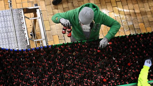 <p>Ein Mitarbeiter von AB InBev sortiert Bierflaschen in der Brauerei in Löwen.</p>