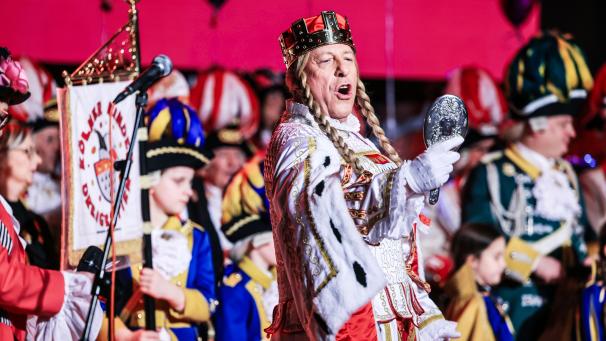 <p>Jungfrau Frieda vom Kölner Dreigestirn singt auf der Bühne.</p>