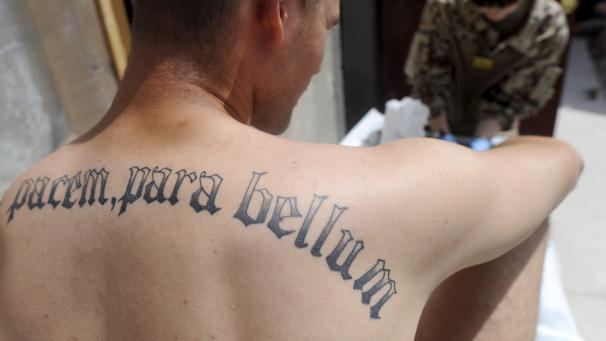 <p>„Si vis pacem, para bellum“ (Wenn du den Frieden willst, rüste zum Krieg) ist auf dem Rücken eines Soldaten tätowiert.</p>