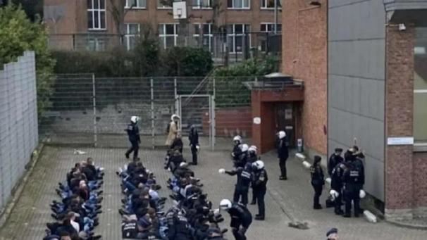 <p>Frankfurt-Fans sitzten aneinander gereiht in der Nähe des Stadions – um sie herum stehen Polizisten.</p>