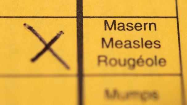 <p>Ein Impfpass mit einem Kreuz bei der Masern-Impfung liegt auf einem Tisch.</p>
