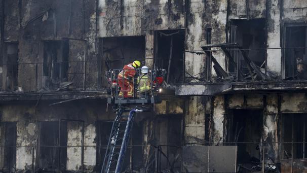 <p>Feuerwehrleute stehen während Löscharbeiten auf einer Hubleiter.</p>