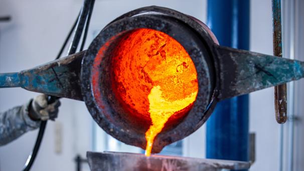 <p>Flüssige Bronze wird in eine Form gekippt.</p>
