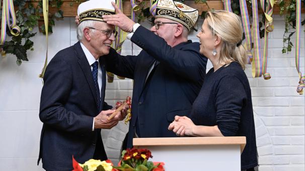 <p>Exprinzen-Präsident Michael Scholl setzt Karl-Heinz Hergenhahn im Beisein von Bürgermeisterin Claudia Niessen die Ordenskappe auf.</p>