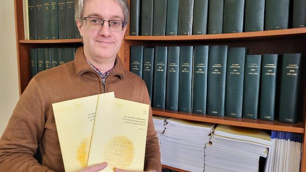 <p>Cédric Istasse mit seiner Schrift über die DG, die ihn drei Jahre in Anspruch nahm.</p>