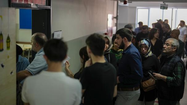 <p>Menschen warten auf ihre Stimmabgabe für die Kommunalwahlen in einem Wahllokal.</p>