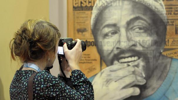 <p>Eine junge Frau fotografiert während einer Musikmesse in Berlin eine Collage, die den US-Sänger Marvin Gaye zeigt.</p>