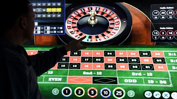 <p>Ein Mann steht vor einem Bildschirm mit einer Seite für Online-Roulette.</p>