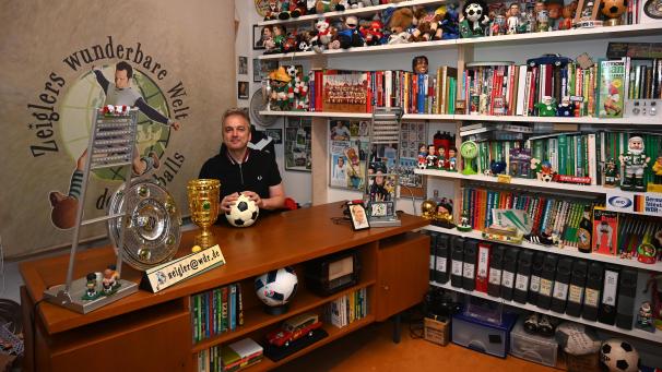 <p>Fußball-Nostalgie, wohin das Auge reicht: Arnd Zeigler in seinem kleinen, vollbepackten Haus-TV-Studio</p>