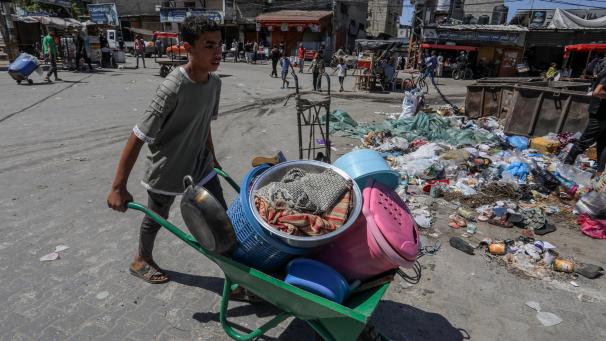 <p>Ein palästinensischer Junge schiebt eine mit persönlichen Gegenständen beladene Schubkarre, als er nach israelischen Luftangriffen auf die Stadtteile Al-Geneina und Al-Salam flieht.</p>